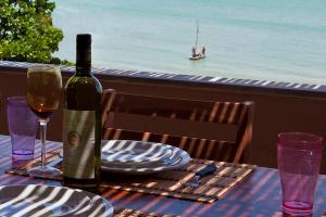 a table with a bottle of wine and plates on it at Coco Beach Apart 5B in Natal
