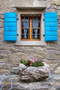 
a blue vase with flowers sitting on a stone wall at House Vera in Hum
