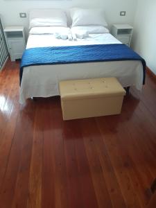 um quarto com uma cama e piso em madeira em Petra Marina Suite em Pisciotta