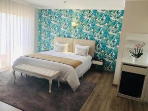 a bedroom with a large bed with a blue wall at Alojamento Restaurante Dom Dinis in Vila Nova de Poiares