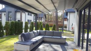 a patio with a couch on a porch at Comfort Villa in Pobierowo
