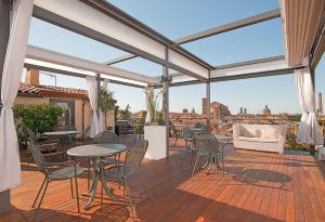 a patio with tables and chairs and a view of the city at Hotel Touring in Bologna