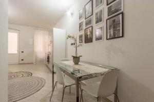 Un comedor con una mesa de cristal y sillas blancas. en Via San Giacomo 10, en Cagliari 19 fotos más