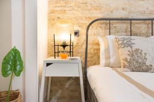 Una cama con una mesita de noche al lado de una cama con una lámpara. en Via San Giacomo 10, en Cagliari