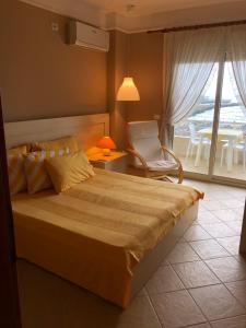 a bedroom with a bed and a chair and a window at Beach View! Seaside Apartment in Durrës