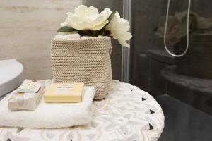 Un baño con una mesa con toallas y un jarrón con flores. en Via San Giacomo 10, en Cagliari