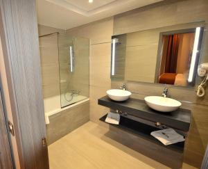 Cheraga的住宿－MADAURE HOTEL，一间带两个水槽和玻璃淋浴间的浴室