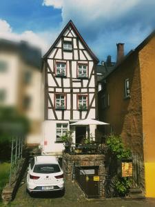 ein weißes Auto, das vor einem Haus parkt in der Unterkunft Gästehaus Pension Romantika in Cochem