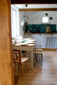 kuchnia ze stołem i krzesłami w pokoju w obiekcie Wiosłówka - domek nad morzem w Gdańsku