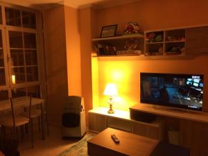 a living room with a television and a table with a lamp at Apartamento junto al paseo marítimo de Cee in Cee