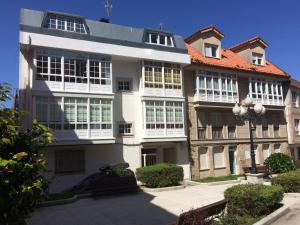 a large white building with an orange roof at Apartamento junto al paseo marítimo de Cee in Cee
