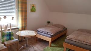 ein Schlafzimmer mit einem Bett, einem Tisch und einem Stuhl in der Unterkunft Apartments Bottrop in Bottrop-Kirchhellen