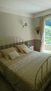 a bedroom with a large bed with a window at B&B La Boissière Et Le Vialat in Montagnac