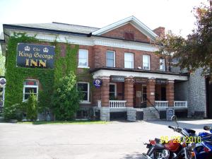 un edificio con una motocicleta estacionada frente a él en The King George Inn en Cobourg
