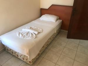 a bed in a room with two towels on it at Muz Hotel in Alanya