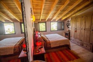 アラハルにあるCasa con encanto en Alájarの木製天井と窓が備わるドミトリールームのベッド2台分です。