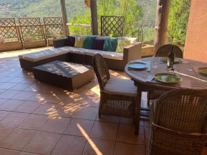 um pátio com um sofá, uma mesa e cadeiras em Villa Pampasgiolu em Tizzano