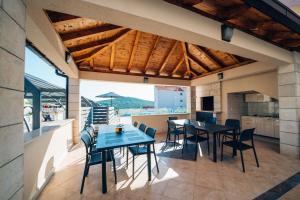 uma cozinha e sala de jantar com mesas e cadeiras em Sun Haven Luxury Apartments em Cavtat