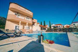 una piscina con un bol de fruta junto a una casa en Sun Haven Luxury Apartments en Cavtat
