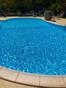 een groot zwembad met blauw water bij Agriturismo Rocce Bianche in Arbus