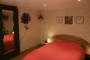 1 dormitorio con 2 camas y una flor en la pared en Gîte Schlitteur Et Sapiniere en Breitenbach