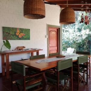 ein Esszimmer mit einem Holztisch und grünen Stühlen in der Unterkunft Oasis Bed and Breakfast in Puerto Iguazú