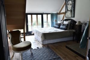 a bedroom with a bed and a chair and a window at Château de Clermont in Clermont-les-Fermes