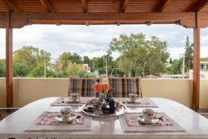 a white table with plates of food on a balcony at Rose's House (Near Airport) in Artemida +14 photos