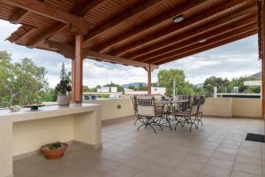 a patio with a table and chairs on a roof at Rose's House (Near Airport) in Artemida