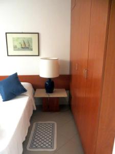 a bedroom with a bed and a table with a lamp at Appartamenti Boboli in Punta Ala