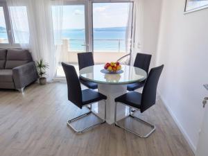 a dining room with a table and chairs with a view at Apartmani Ticinovic in Omiš