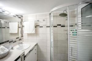 baño blanco con ducha y lavamanos en Leo's home, en Atenas
