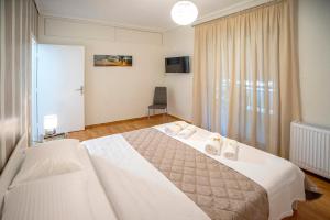a bedroom with a large white bed and a window at Leo's home in Athens