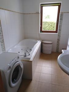 a bathroom with a tub and a toilet and a sink at Řikovice Prázdninový dům in Morašice