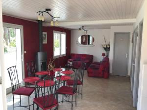 a dining room with red chairs and a table at Maison Sapinettes in Quend