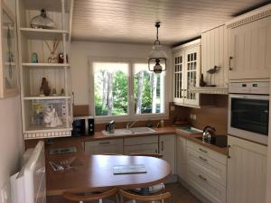 a kitchen with a table and a sink and a window at Maison Sapinettes in Quend