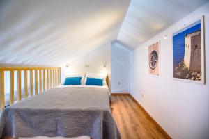 a bedroom with a large bed with blue pillows at California Apartments 3 in Dubrovnik +53 photos