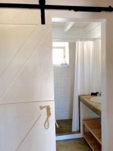 bagno con tenda da doccia bianca e lavandino di Casas de Seixe a Baiana