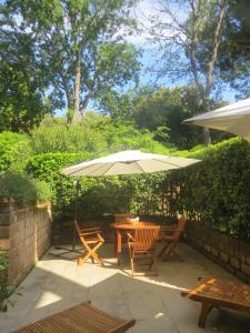 a patio with a table and chairs and an umbrella at Appartamenti Boboli in Punta Ala