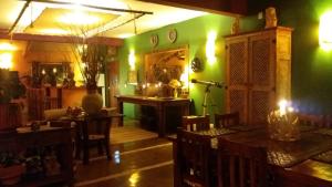 クーニャにあるPousada Celeiro do Guttoの緑の壁のリビングルーム(テーブル、椅子付)