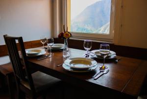 een houten tafel met borden en wijnglazen erop bij Kmetija Na Čendavš in Cerkno