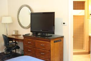 a bedroom with a bed, desk and television at Cozy Corner Motel in Williamstown