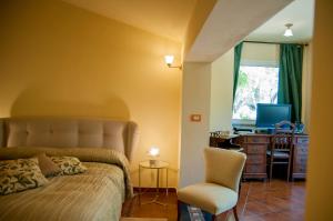 sypialnia z łóżkiem, krzesłem i biurkiem w obiekcie B&B La Villa w mieście Giardini Naxos