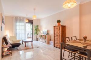 uma sala de estar com uma mesa e uma cadeira em Beach and golf apartament em Benalmádena