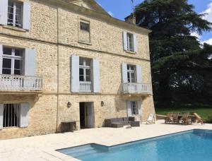 a large stone building with a swimming pool in front of it at Château Mauras in Bommes