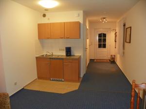 an empty kitchen with wooden cabinets and a hallway at Gemütlich privat allergiearm in Timmendorfer Strand