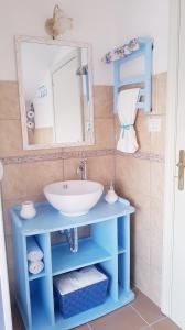 y baño con lavabo azul y espejo. en B&B Kalinìkta, en Ascea