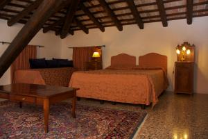 a bedroom with two beds and a coffee table at Villa Cigolotti in Vivaro
