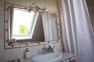 baño con lavabo, espejo y ventana en Villa Relax KomfortLak, en Gárdony