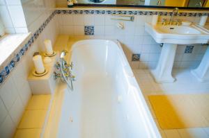 a white bathroom with a tub and a sink at B&B La Villa in Giardini Naxos